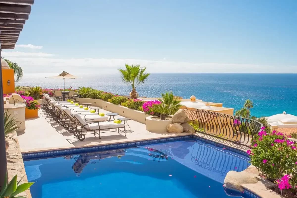 Swimming pool 2 at Lovers Beach Cabo with ocean beyond, palm trees