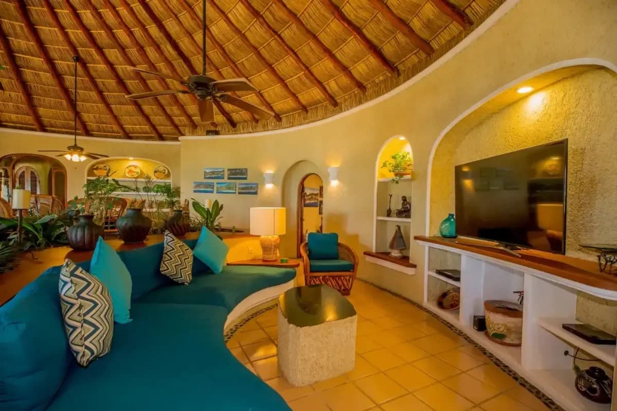 Living area 4 at Best Couples Massage Cabo with blue sofa, arched doorways