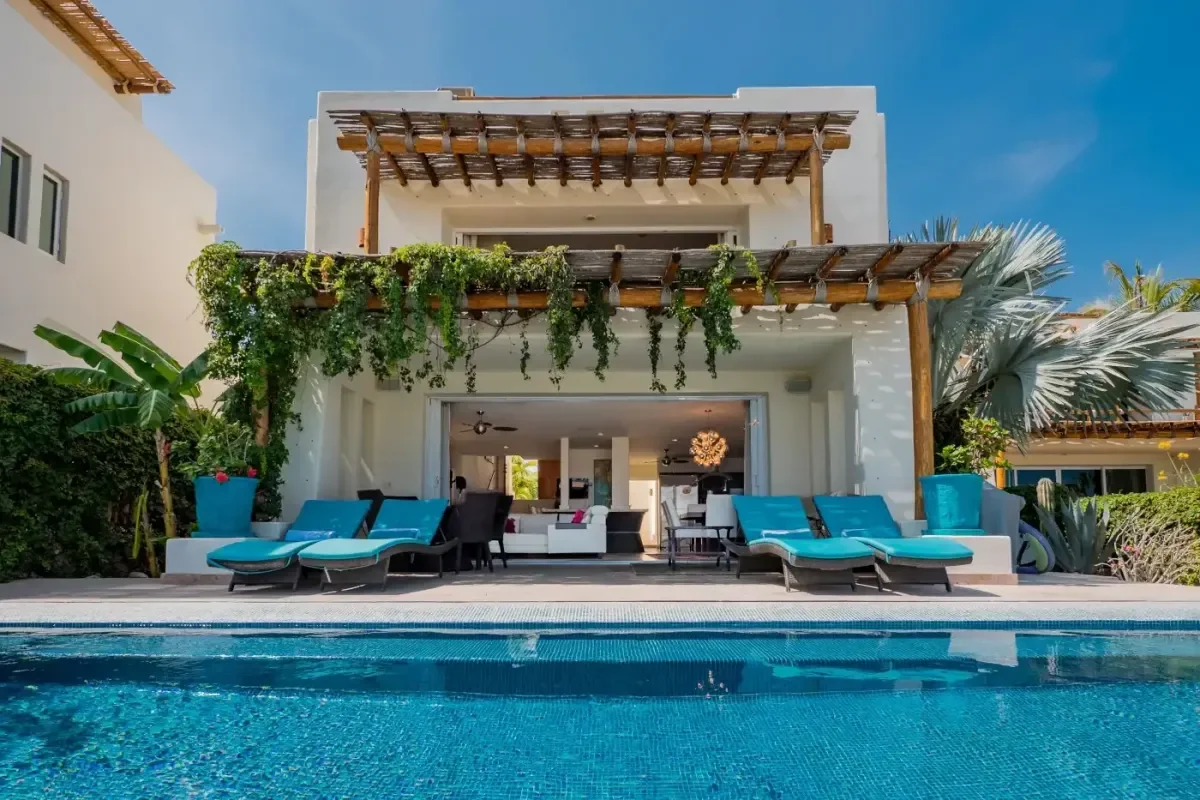 Pool to house at Villa Sirena with open sliding doors, blue sky in Cabo