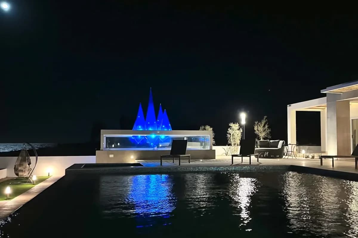 Infinity pool at Palmilla Beach at night, with blue peaks