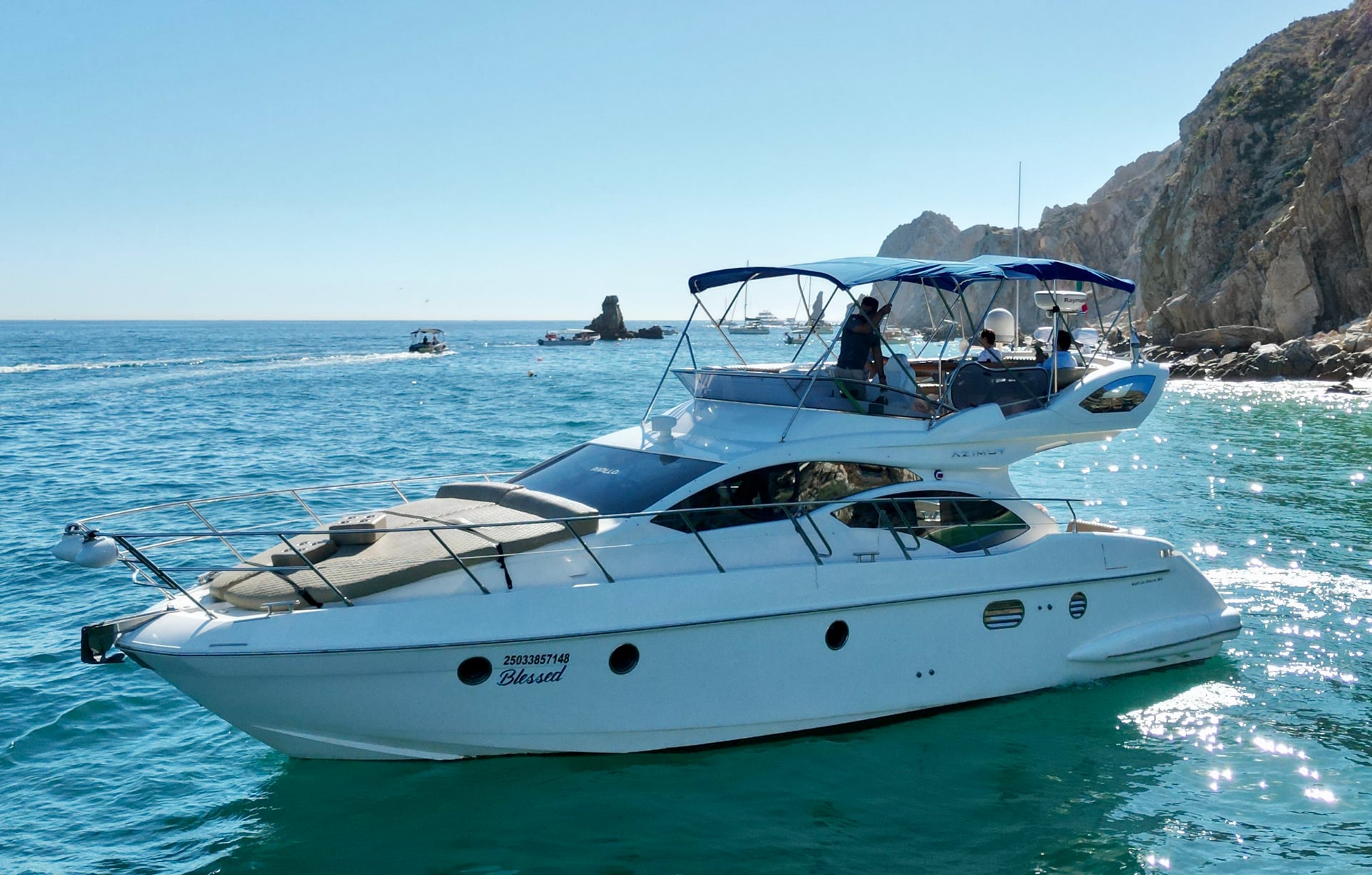 Boat side on the Azimut 46ft with rock formations, other boats in Cabo San Lucas