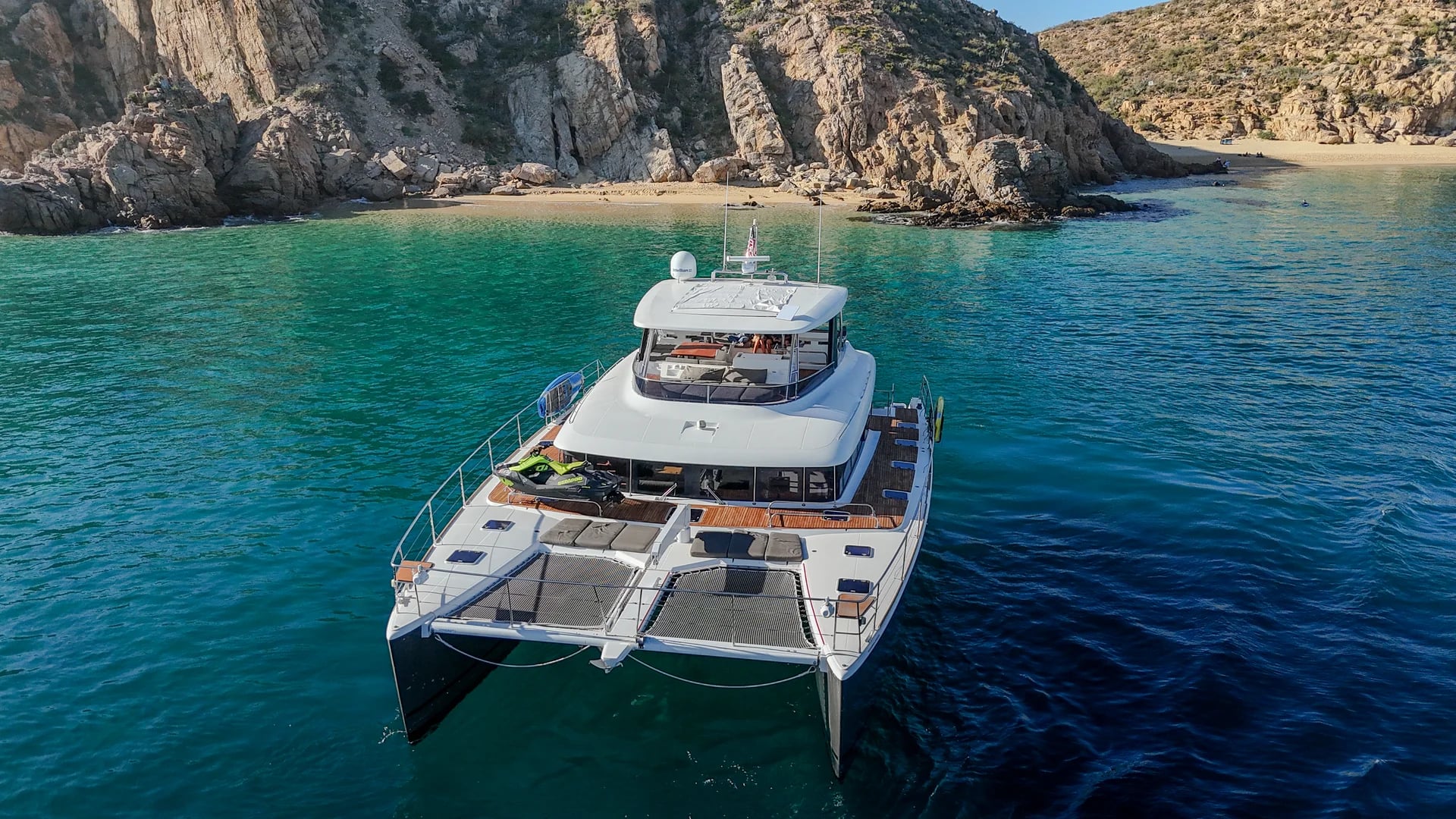 Catamaran yacht bow on the Lagoon 65ft Catamaran aerial with rocky-coast in Cabo San Lucas