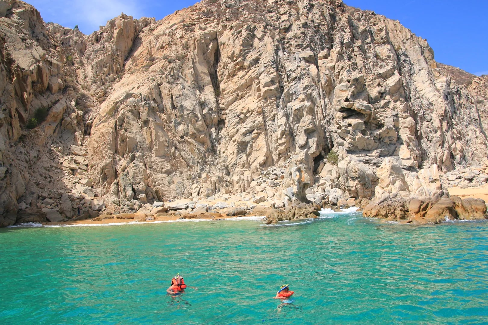 Rocky cliff on the Yamaha 28ft with clear water, small beach in Cabo San Lucas